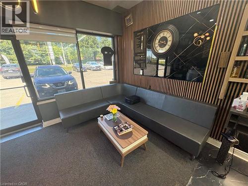 Spacious reception area with a large L-shaped seating arrangement, modern slatted wood accent wall, and expansive storefront windows - 209 Lexington Road Unit# F, Waterloo, ON 