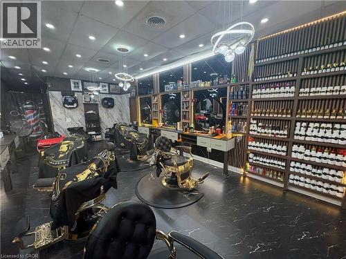 Barber shop interior featuring multiple styling stations with upholstered chairs, black and white marble-look flooring, and recessed lighting - 209 Lexington Road Unit# F, Waterloo, ON 
