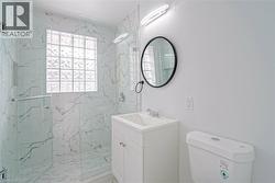 Tiled shower with glass enclosure, integrated niche, and glass block window - 