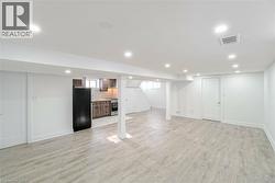 Open-concept living area featuring light wood-finish flooring and recessed lighting - 