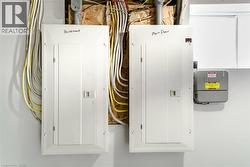 Dual electrical panels featuring dedicated ""Basement"" and ""Main Floor"" circuits, accompanied by an irrigation control box - 