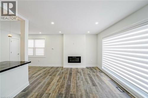 Spacious interior featuring wood-finish flooring, recessed lighting, and an electric fireplace - 8 Marlborough Road, Guelph, ON - Indoor With Fireplace