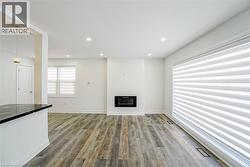Spacious interior featuring wood-finish flooring, recessed lighting, and an electric fireplace - 