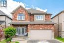 Red brick and stone facade residence featuring a two-car garage, covered entry with double doors, and an arched window - 79 Garinger Crescent, Hamilton, ON  - Outdoor With Exterior 