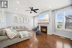 Living area featuring wood-finish flooring, recessed lighting, and a ceiling fan - 