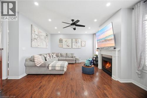 Bright living area featuring rich wood-finish flooring, recessed lighting, and a ceiling fan - 79 Garinger Crescent, Hamilton, ON - Indoor Photo Showing Living Room With Fireplace