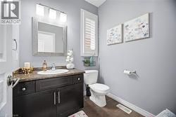 Powder room featuring a dark wood-finish vanity with an integrated sink and a brown speckled countertop - 
