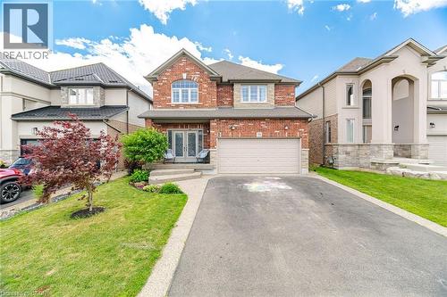 Brick and stone facade residence featuring a double-door entry, an attached two-car garage, an arched window, and a concrete pathway leading to the front entrance - 79 Garinger Crescent, Hamilton, ON - Outdoor With Facade