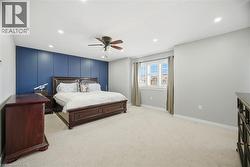Spacious interior featuring a blue accent wall with panel detailing, light grey walls, and plush carpeting - 