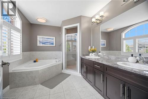 Bathroom featuring a corner soaking tub, a separate glass-enclosed shower, and a dual vanity with dark wood cabinetry - 79 Garinger Crescent, Hamilton, ON - Indoor Photo Showing Bathroom
