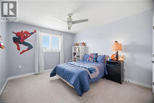 Carpeted bedroom with a ceiling fan, baseboard molding, and a window featuring white plantation shutters - 79 Garinger Crescent, Hamilton, ON - Indoor Photo Showing Bedroom