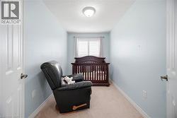 Room featuring light blue walls, white trim, and neutral carpet flooring - 