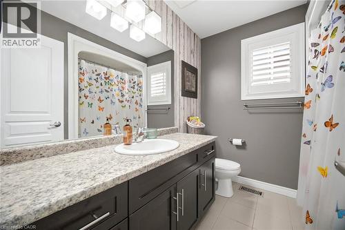 Bathroom featuring a dark wood-finish vanity with a light speckled countertop and undermount sink - 79 Garinger Crescent, Hamilton, ON - Indoor Photo Showing Bathroom