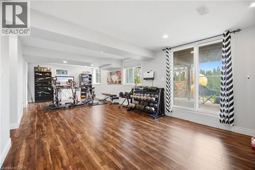 Spacious lower-level room featuring wood-finish flooring and recessed lighting - 79 Garinger Crescent, Hamilton, ON - Indoor Photo Showing Gym Room