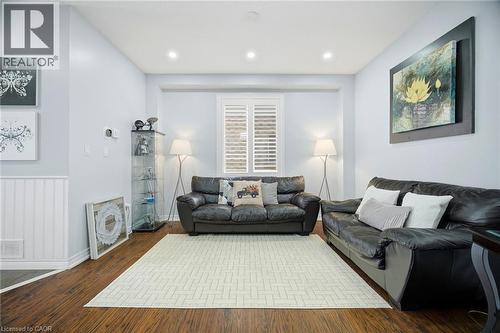 Spacious living area featuring rich wood-finish flooring, recessed lighting, and a window with white plantation shutters - 79 Garinger Crescent, Hamilton, ON - Indoor Photo Showing Living Room
