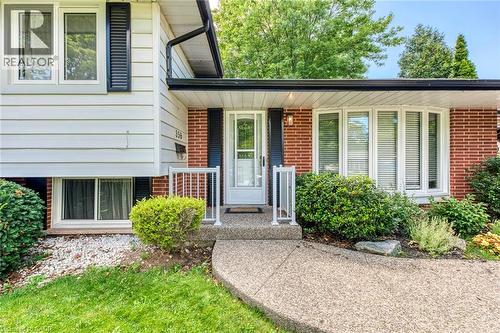 Exterior featuring white siding, red brick accents, black shutters, and an exposed aggregate walkway - 356 Dunlop Crescent, Burlington, ON - Outdoor