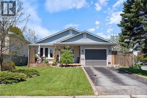 Bungalow-style residence featuring a light brick exterior and blue siding accents - 2 Hampton Court, Port Dover, ON - Outdoor With Deck Patio Veranda With Facade