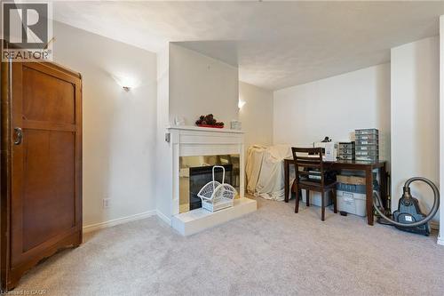 Fireplace with a white wood mantel, tile hearth, and brass-tone firebox surround - 2 Hampton Court, Port Dover, ON - Indoor Photo Showing Other Room
