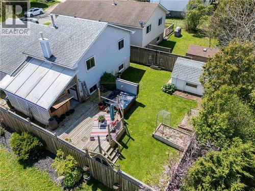 Expansive rear yard featuring a multi-level wood-finish deck with integrated steps, a covered patio area, and a detached storage shed - 2 Hampton Court, Port Dover, ON - Outdoor With Exterior