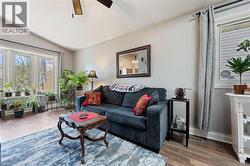 Living area with wood-finish flooring, featuring a bay window with multiple panes - 