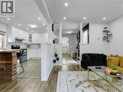 Open-concept living space featuring wood-finish flooring, recessed lighting, and a kitchen with white cabinetry - 209 Briarmeadow Drive, Kitchener, ON - Indoor Photo Showing Kitchen