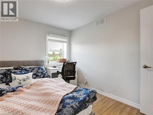 Neutral wall paint and wood-finish flooring - 209 Briarmeadow Drive, Kitchener, ON - Indoor Photo Showing Bedroom