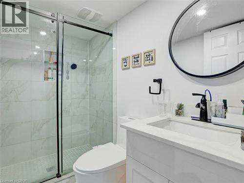 Frameless glass shower with black hardware, marble-look tile surround, and a recessed shower niche - 209 Briarmeadow Drive, Kitchener, ON - Indoor Photo Showing Bathroom
