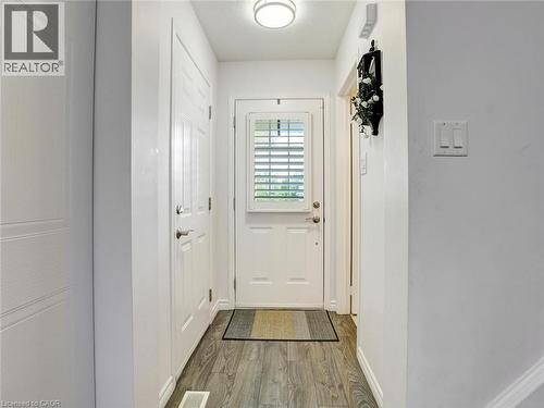 Entryway with wood-finish flooring, white paneled doors, and a front door featuring an integrated louvered window - 209 Briarmeadow Drive, Kitchener, ON - Indoor Photo Showing Other Room
