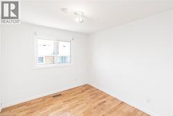 Room featuring light wood flooring and white baseboards - 