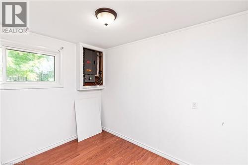 Interior space featuring wood-finish flooring, white walls, and a window with natural light - 100 Mountain Avenue N, Hamilton, ON - Indoor Photo Showing Other Room