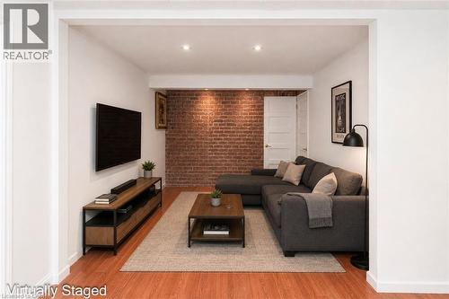 Exposed brick accent wall with recessed lighting - 100 Mountain Avenue N, Hamilton, ON - Indoor Photo Showing Living Room