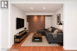Exposed brick accent wall with recessed lighting - 