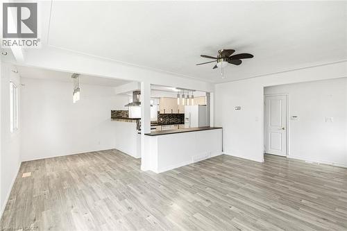 Open-concept living space featuring wood-finish flooring, white walls, and a ceiling fan - 100 Mountain Avenue N, Hamilton, ON - Indoor Photo Showing Kitchen