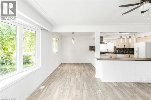 Open-concept living area with wood-finish flooring, white walls, and exposed ceiling beams - 100 Mountain Avenue N, Hamilton, ON - Indoor Photo Showing Kitchen