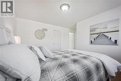 Spacious room featuring white walls, a textured ceiling, a flush-mount ceiling light fixture, and white interior doors - 
