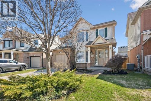 Two-story residential exterior featuring a brick and siding facade, a covered front porch, and a bay window - 5147 Ravine Crescent, Burlington, ON - Outdoor
