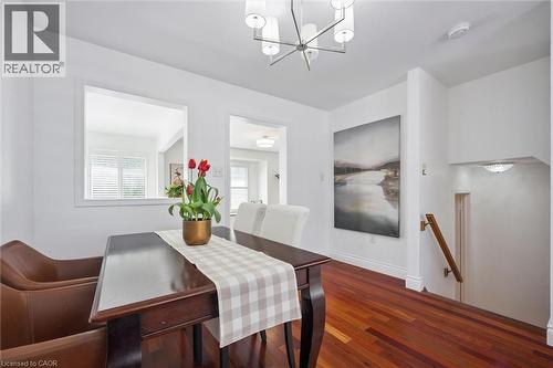 Dining area featuring rich wood-finish flooring, a contemporary chandelier, and an interior pass-through window - 5147 Ravine Crescent, Burlington, ON - Indoor Photo Showing Other Room