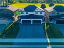 Modern semi-detached residence featuring a two-car garage, dark asphalt driveway, and light gray brick facade - 111 Amber Street, Waterford, ON  - Outdoor 