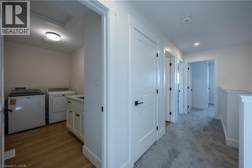 Dedicated laundry room with wood-finish flooring, built-in cabinetry, and a countertop - 111 Amber Street, Waterford, ON - Indoor