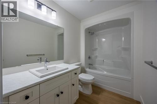 Bathroom featuring a white vanity with a rectangular sink, a light-toned countertop, and wood-finish flooring - 111 Amber Street, Waterford, ON - Indoor Photo Showing Bathroom
