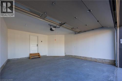 Spacious garage featuring a concrete floor, white painted walls, and a finished ceiling with an automatic opener - 115 Amber Street, Waterford, ON - Indoor Photo Showing Garage