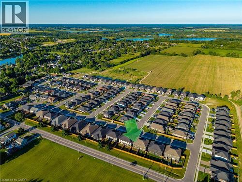Aerial perspective showcasing a residential development with surrounding green spaces and distant bodies of water - 115 Amber Street, Waterford, ON - Outdoor With View