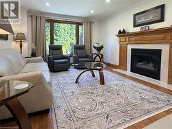 The inviting family room offers a gas fireplace, hardwood flooring and a large picture window overlooking the beautifully landscaped backyard - 