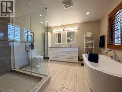 Luxurious spa-inspired ensuite complete with a freestanding soaker tub, double vanity and glass walk-in shower. - 