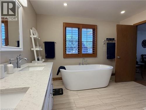 Upstairs, the oversized primary suite features a generous walk-in closet and a luxurious spa-inspired ensuite complete with a freestanding soaker tub and glass walk-in shower. Solid wood interior door - 7 Mann Avenue, Simcoe, ON - Indoor Photo Showing Bathroom