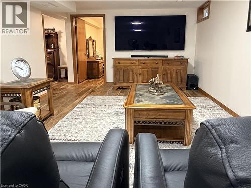 Spacious living area featuring wood-finish flooring, a large area rug, and a wood media console - 7 Mann Avenue, Simcoe, ON - Indoor Photo Showing Living Room