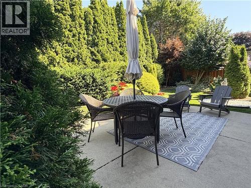 Outdoor patio featuring a concrete surface and mature perimeter landscaping - 7 Mann Avenue, Simcoe, ON - Outdoor With Deck Patio Veranda