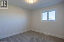 Neutral-toned room featuring a double-pane window with white trim, gray carpet flooring, and white baseboards - 