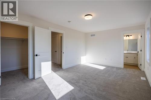 Spacious bedroom with light gray carpeting, crisp white walls, and a recessed closet - 107 Amber Street, Waterford, ON - Indoor Photo Showing Other Room