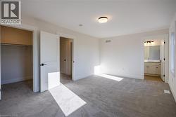 Spacious bedroom with light gray carpeting, crisp white walls, and a recessed closet - 